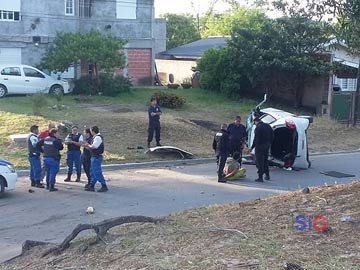 Policias en accion: el fugitivo detenido y el auto destrozado (Foto: H Arrayago)